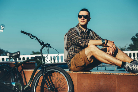 年轻人坐在喷泉旁边中夏公园日常生活方式城市休息概念自行车骑自行车的人