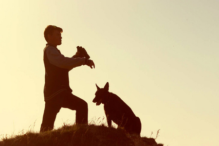 男人和他的狗站在山顶上