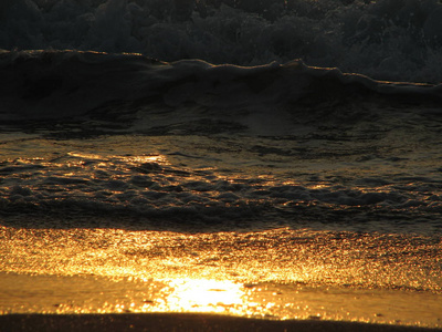 海滩日落是与被海浪卷的夕阳的天空