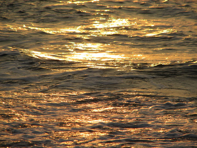 海滩日落是与被海浪卷的夕阳的天空