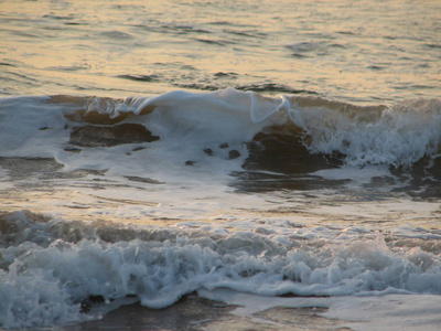 海滩日落是与被海浪卷的夕阳的天空