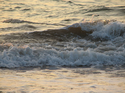海滩日落是与被海浪卷的夕阳的天空