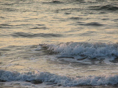 海滩日落是与被海浪卷的夕阳的天空