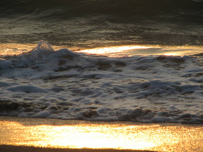 海滩日落是与被海浪卷的夕阳的天空