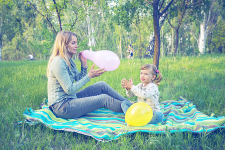 母亲带着女儿有趣膨胀五颜六色的气球，在 p