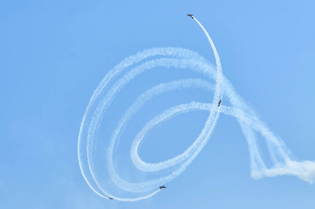 蓝蓝的天空背景上的白色迹跟踪.体育飞机特技飞行机动特技.
