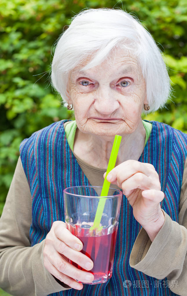 老女人喝覆盆子果汁的老年痴呆症
