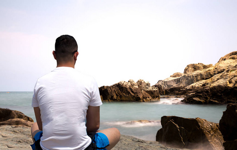 人坐在海边做冥想的岩石