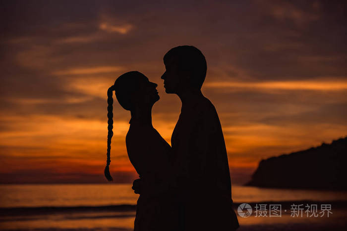 在twlilight与日落背景中拥抱的浪漫恋人