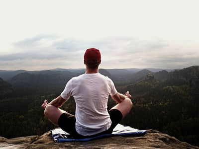 瑜伽练习在山区问题首脑会议与山谷的鸟瞰图。高大的运动员练习瑜伽