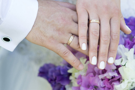 手中只是已婚夫妇与金色的结婚戒指和甜