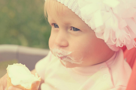 一个小女孩在吃冰淇淋和弄脏她的脸