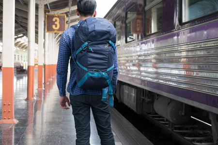 站在火车站月台上,背包里的亚洲人.b照片