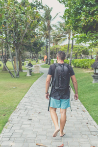 人走在海滩公园的努沙杜阿，巴厘岛，印度尼西亚，背包里的后视图