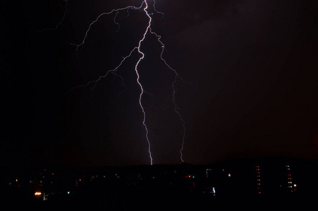城市上空雷雨时雷击飑门和在夜晚的微光城市上空的雷雨云雷雨闪电击中