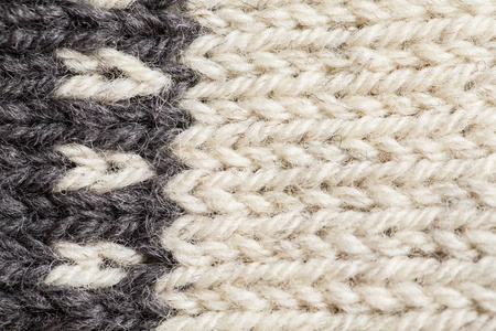 美丽的特写镜头的手温暖和柔软羊毛针织物的模式。软的袜子或天然羊毛围巾。炫彩花纹