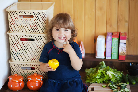 小女孩在厨房里吃番茄