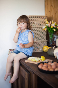 有趣的小女孩烹饪苹果馅饼在厨房里，吃苹果