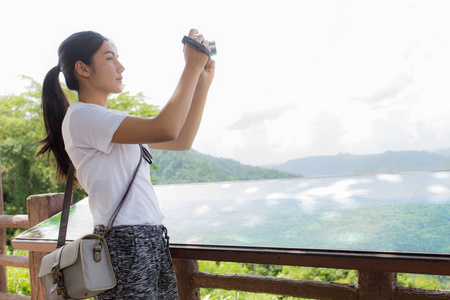 女人的徒步旅行者在山相机合影