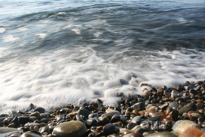 鹅卵石海滩上的海上冲击波泡沫