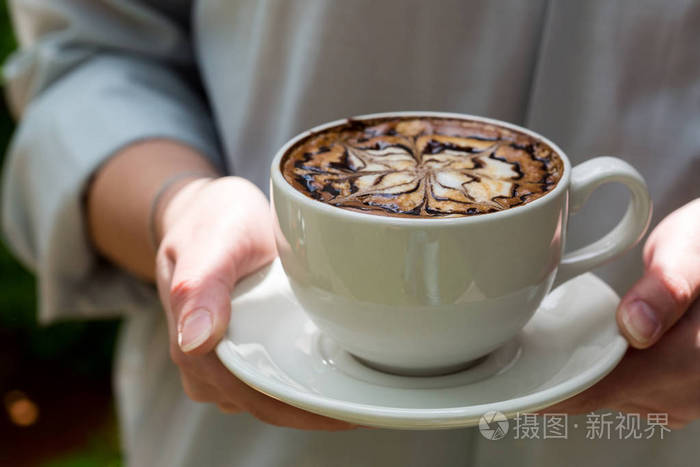 女人拿着杯热咖啡.女性手里拿着杯咖啡之字形焦糖