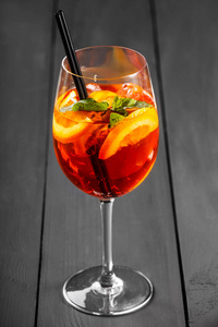与可乐 冰 薄荷和橙色的木制背景上的酒杯冷含酒精的鸡尾酒。夏季饮料