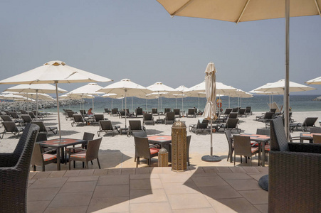 热带天堂。与日光躺椅和遮阳伞在迪拜，波斯湾沿岸的海滩。酋长国的哈伊。有色
