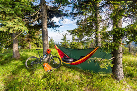 和夏天树林自行车旅行中的吊床野营