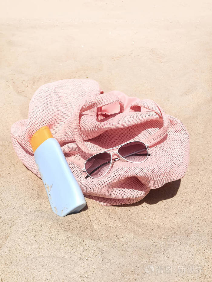沙滩上的包,防晒霜,太阳镜