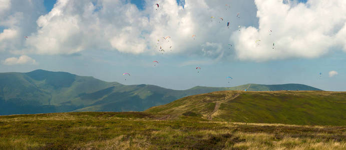 山上天空中一大群滑翔伞的全景照片