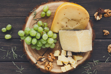奶酪拼盘，gouda 草本天然木材光盘与葡萄上的和