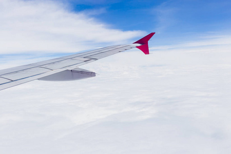 从飞机窗口观看。 飞行在云层之上的飞机的机翼