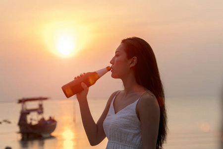 年轻女子捧着瓶啤酒