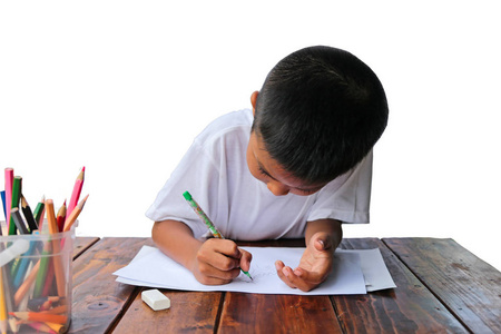 亚洲的小男孩，用铅笔在白纸上的木桌和白色背景画漫画。小画家概念