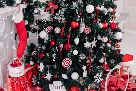 装饰圣诞树在家。装饰品紧靠的圣诞树彩灯和玩具，文本的副本空间背景