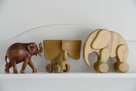 三个木大象雕塑在一个中立的背景
