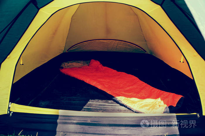 在帐篷里的橙色睡袋里。