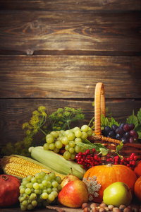 快乐的感恩节背景，木桌前，装饰着蔬菜 水果和秋天的落叶。秋天的背景