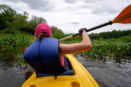 年轻的女孩在河上划船划艇粉色的帽子，从查看