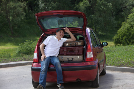 一个男人加载他的汽车行李箱图片
