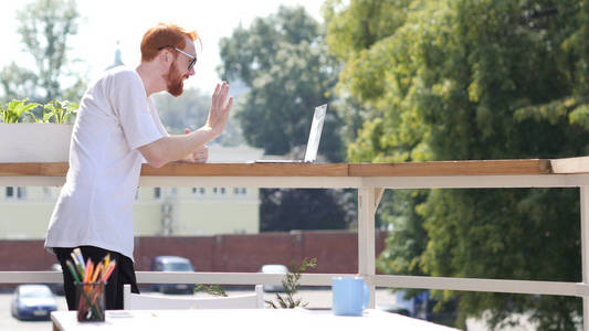年轻人的笔记本电脑，聊天，站在阳台户外视频会议