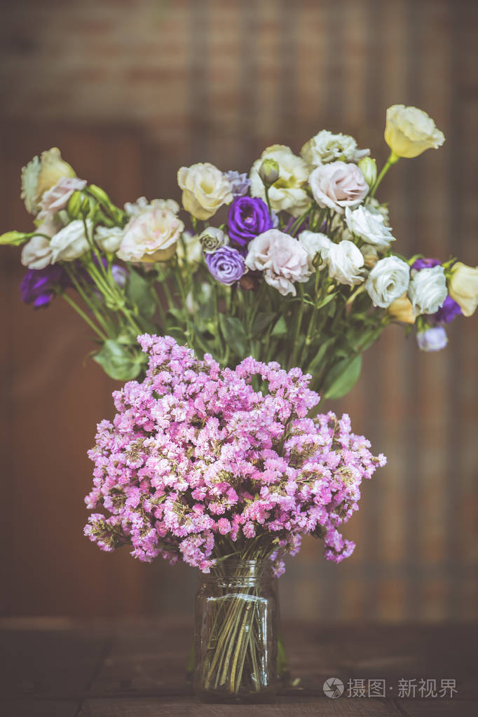 一束紫色花玻璃上的花瓶里木地板博