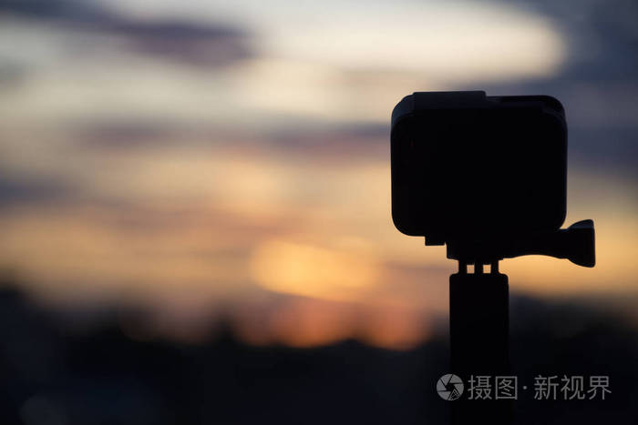 剪影抽象操作相机在黄昏黎明的天空,技术与自然观