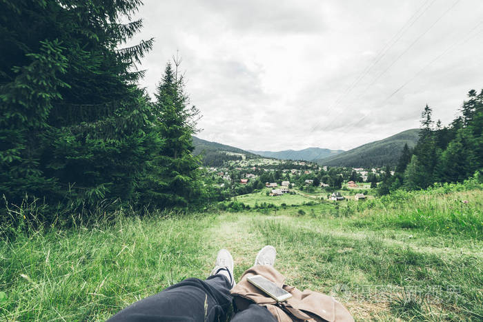 男子躺在地上一边欣赏着山的景色