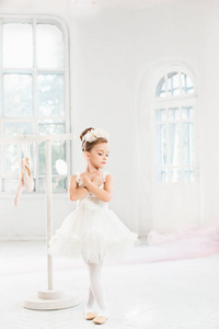 芭蕾舞女演员的小姑娘兔兔。在一个白色的工作室跳舞古典芭蕾的可爱孩子