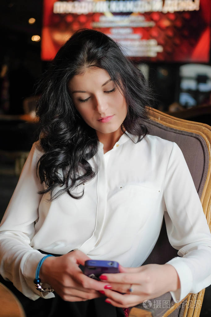 年轻的女孩抱着一部智能手机.上班族的午餐.商务会议.发送一条消息