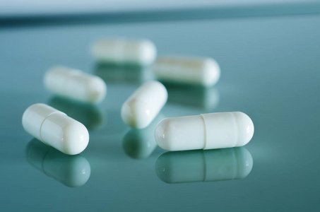 胶囊肠镜白色的医用胶囊躺在镜面上照片