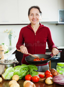 正成熟女人用煎锅做饭