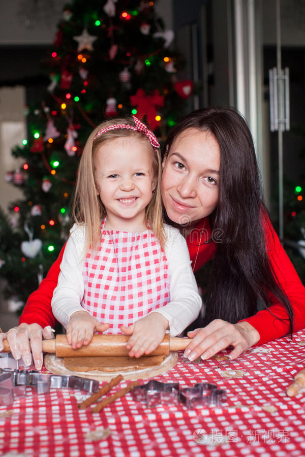 小女孩和漂亮的妈妈一起烤圣诞节