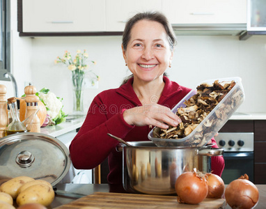 炖辣椒和马铃薯切菜煲汤快乐妈妈带孩子煲汤普通女孩在家里煲汤
